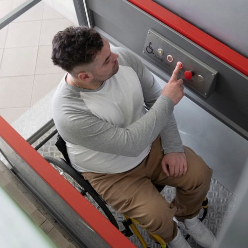 full-shot-man-wheelchair-using-elevator_23-2149445643